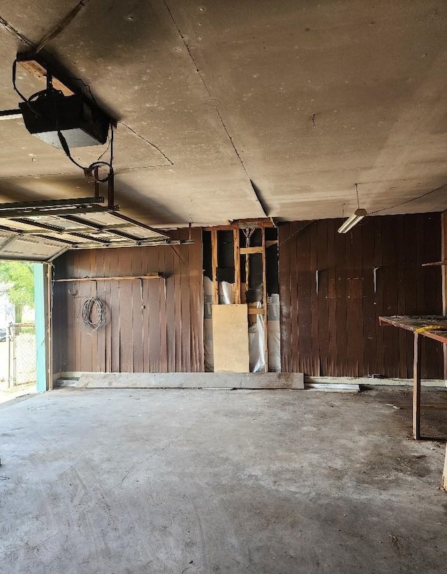 garage featuring wood walls and a garage door opener