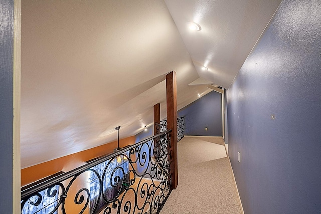 hallway with carpet and lofted ceiling