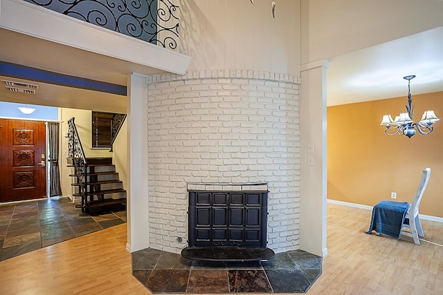 living room with a fireplace, hardwood / wood-style floors, and an inviting chandelier