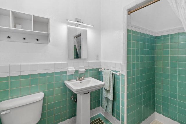 2695 Sandlin St, Beaumont, TX 77707 - bathroom featuring toilet, a wainscoted wall, tile walls, and a tile shower