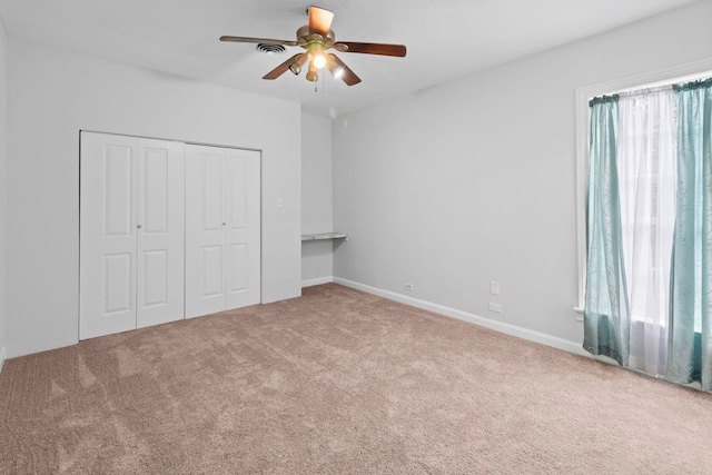 2695 Sandlin St, Beaumont, TX 77707 - unfurnished bedroom with multiple windows, carpet floors, a closet, and a ceiling fan