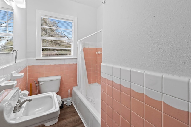 2695 Sandlin St, Beaumont, TX 77707 - full bathroom featuring tile walls, toilet, healthy amount of natural light, a wainscoted wall, and shower / bath combo with shower curtain
