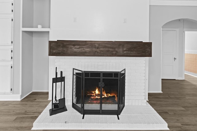2695 Sandlin St, Beaumont, TX 77707 - detailed view of wood finished floors, a fireplace, arched walkways, and baseboards