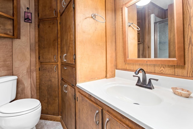 bathroom featuring vanity, an enclosed shower, and toilet