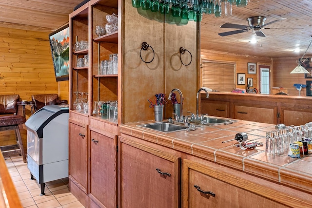 kitchen with tile countertops, wood walls, light tile patterned floors, and wood ceiling