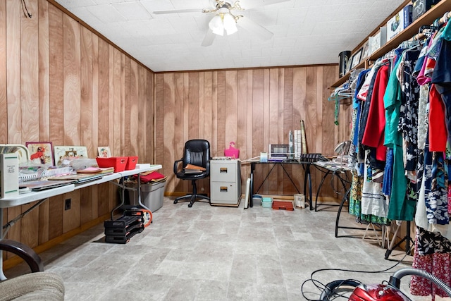 interior space featuring ceiling fan and wooden walls