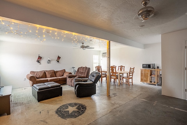 living room featuring ceiling fan, concrete flooring, and a textured ceiling