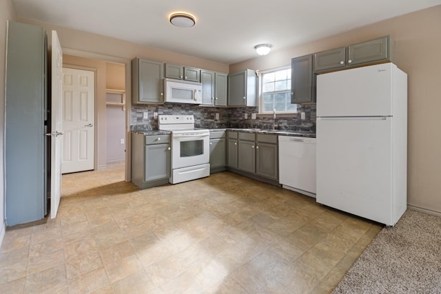 kitchen featuring gray cabinets, white appliances, sink, and tasteful backsplash