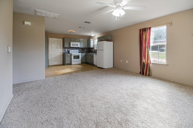 kitchen featuring gray cabinetry, ceiling fan, light colored carpet, white appliances, and decorative backsplash