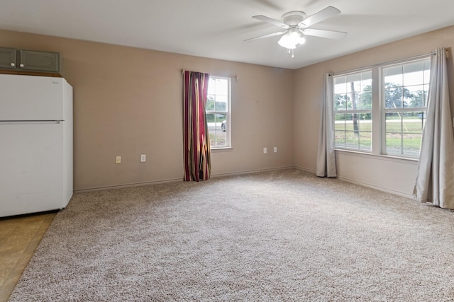 carpeted spare room featuring ceiling fan