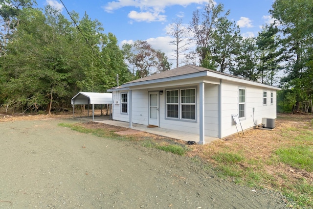 view of front of house featuring central air condition unit, covered porch, and a carport