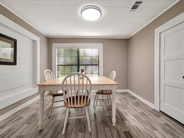 dining room featuring hardwood / wood-style flooring and ornamental molding