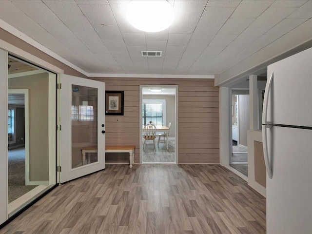 interior space featuring wood walls and light hardwood / wood-style flooring