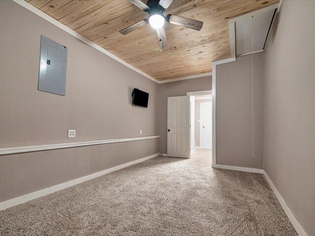 carpeted spare room with electric panel, ceiling fan, crown molding, and wood ceiling