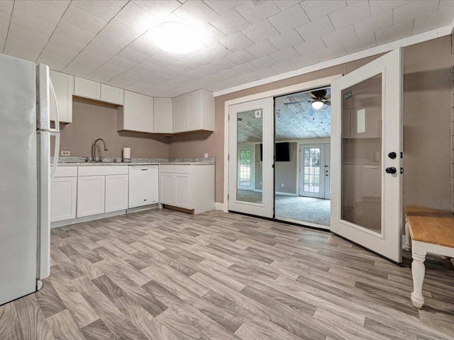 kitchen featuring french doors, light wood-type flooring, white appliances, sink, and white cabinets