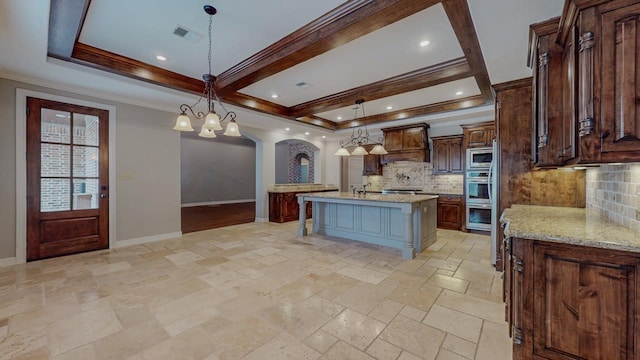 416 Birch View Dr, Lumberton, TX 77657 - kitchen featuring appliances with stainless steel finishes, arched walkways, stone tile floors, tasteful backsplash, and a center island with sink