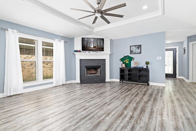 12945 Westchester Ln, Beaumont, TX 77713 - unfurnished living room with wood finished floors, a ceiling fan, a tiled fireplace, a tray ceiling, and baseboards