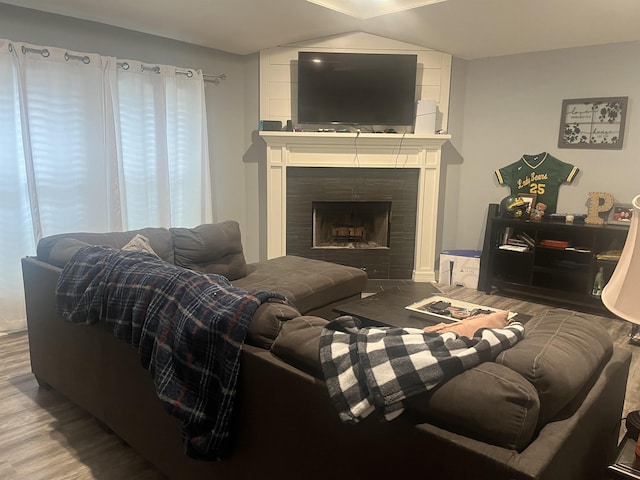 living area featuring a tiled fireplace and wood finished floors