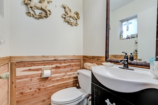 bathroom featuring toilet, vanity, and ornamental molding