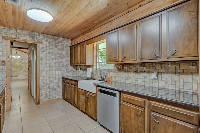 kitchen with dishwasher, a sink, wooden ceiling, light tile patterned floors, and dark stone counters