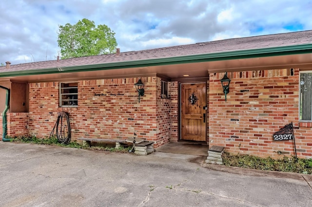 entrance to property featuring brick siding