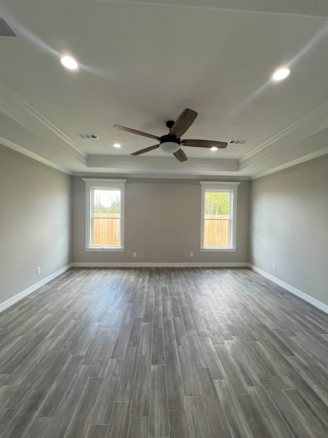 spare room with a raised ceiling, visible vents, and a healthy amount of sunlight