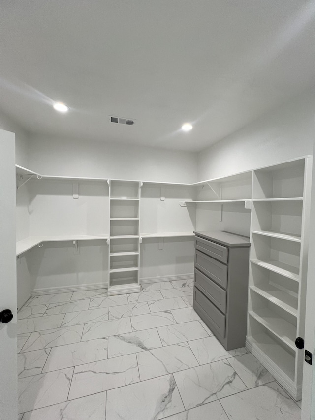 walk in closet featuring marble finish floor and visible vents