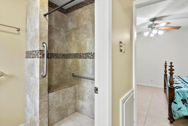 bathroom with tile patterned floors, ceiling fan, a tile shower, and a textured ceiling