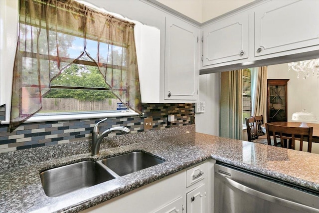 kitchen featuring decorative backsplash, stainless steel dishwasher, sink, a notable chandelier, and white cabinetry