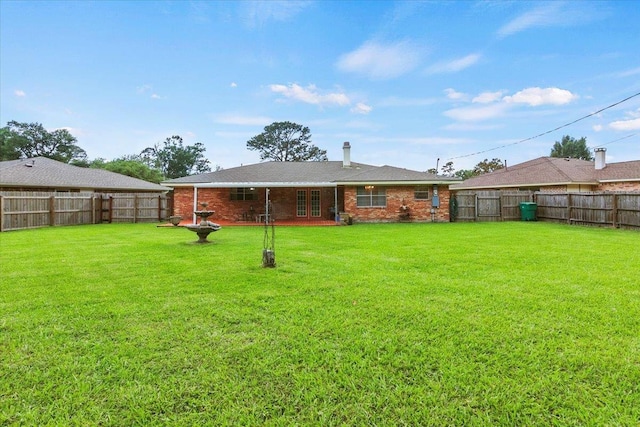 rear view of property featuring a lawn