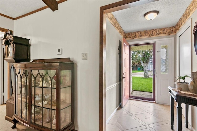 tiled entrance foyer with beam ceiling and a textured ceiling