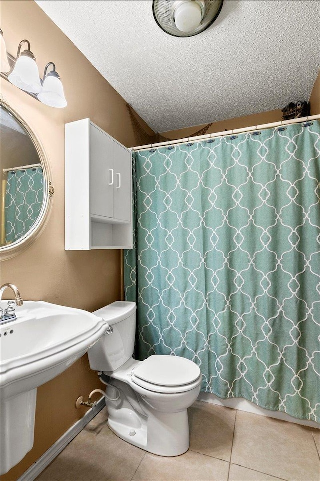 bathroom featuring tile patterned floors, sink, a textured ceiling, and toilet