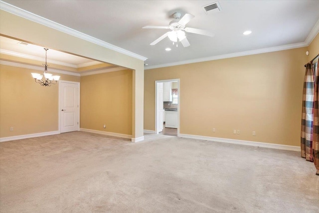 spare room featuring light colored carpet, ceiling fan with notable chandelier, visible vents, baseboards, and crown molding