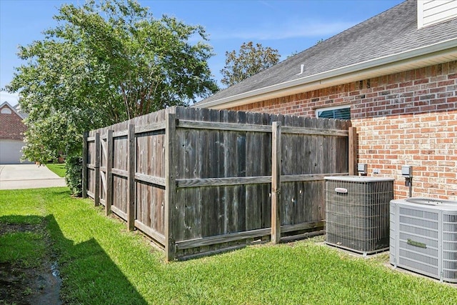 view of yard with fence and central AC