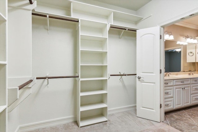 walk in closet featuring light carpet and a sink