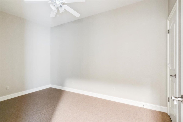 unfurnished room with baseboards, dark carpet, and a ceiling fan