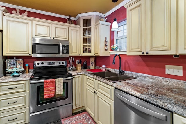 kitchen with sink, ornamental molding, cream cabinetry, decorative light fixtures, and stainless steel appliances