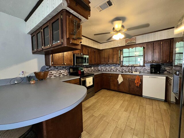 kitchen featuring visible vents, ceiling fan, stainless steel appliances, dark brown cabinetry, and a sink