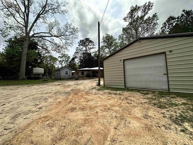 view of yard featuring an outdoor structure and driveway