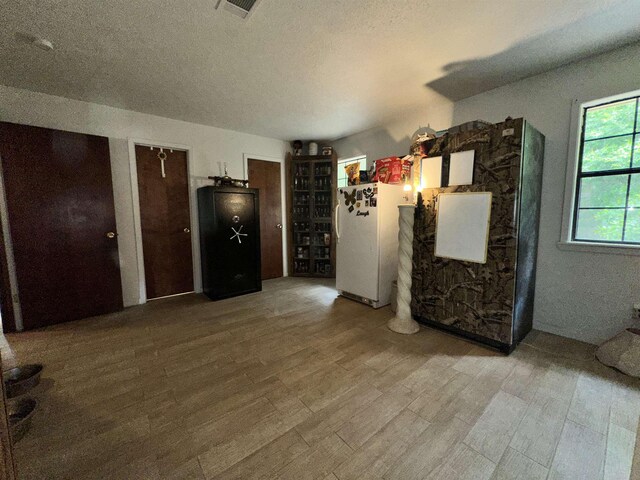 interior space with visible vents, wood finished floors, and a textured ceiling