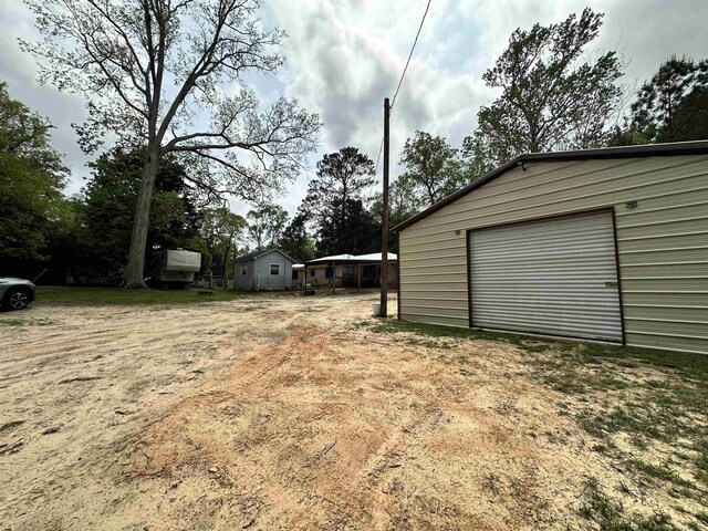 view of yard with driveway and an outdoor structure