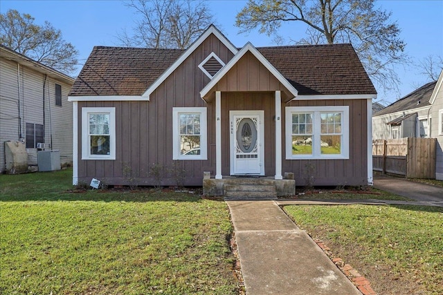 bungalow-style house with a front yard, fence, and board and batten siding