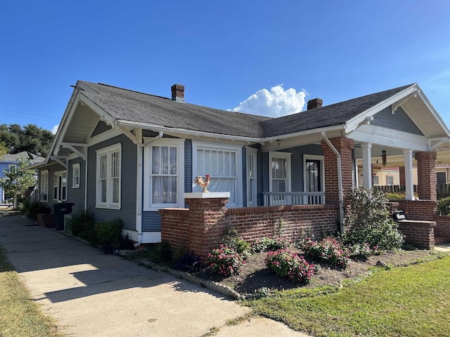 view of side of property featuring covered porch