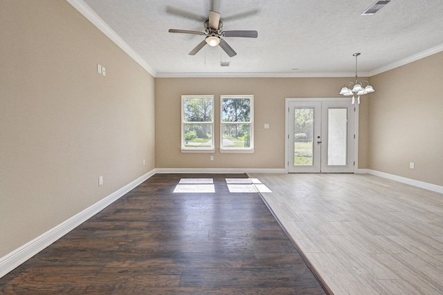 empty room featuring dark hardwood / wood-style flooring, ornamental molding, a textured ceiling, and french doors