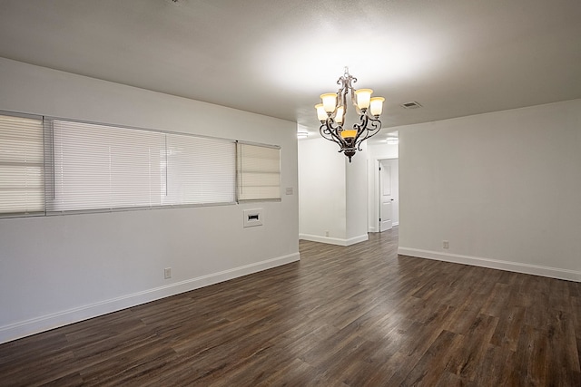 unfurnished dining area with an inviting chandelier, baseboards, visible vents, and dark wood-style floors