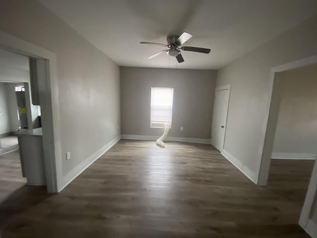 empty room featuring ceiling fan and dark wood-type flooring