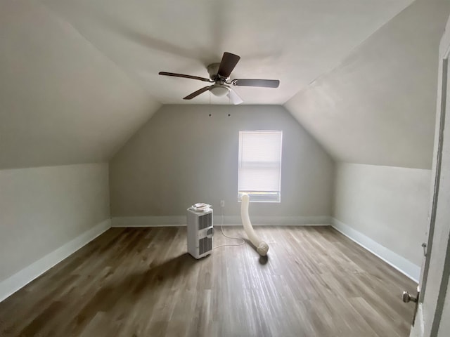 additional living space with ceiling fan, wood-type flooring, and vaulted ceiling