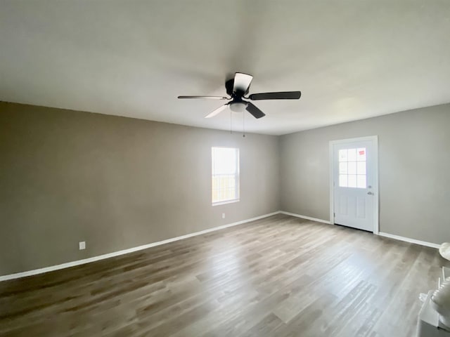 spare room with hardwood / wood-style flooring, a wealth of natural light, and ceiling fan