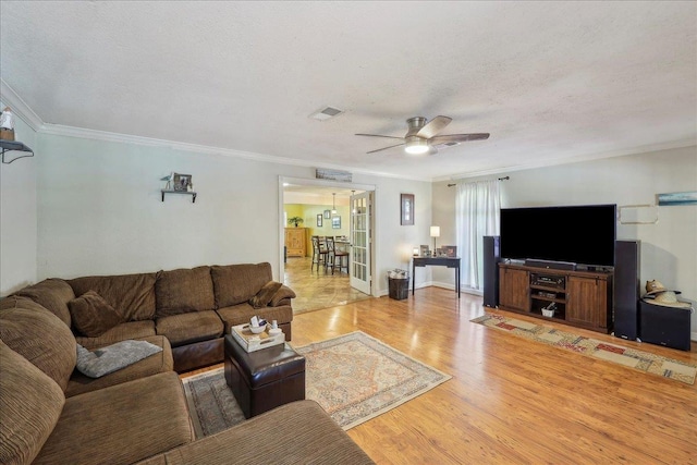 319 Dixie Dr, Bridge City, TX 77611 - living room with a ceiling fan, light wood-style flooring, crown molding, and a textured ceiling