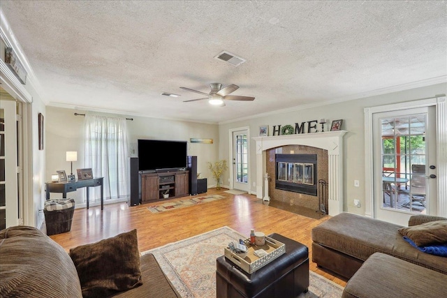 319 Dixie Dr, Bridge City, TX 77611 - living area with plenty of natural light, a textured ceiling, ornamental molding, wood finished floors, and a fireplace